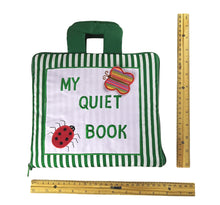 Green and white striped 'My Quiet Book' with ladybug and butterfly design, next to a ruler for scale.